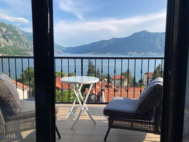 a balcony with a table and chairs and a view of the water at Apartments FANTASY in Kotor