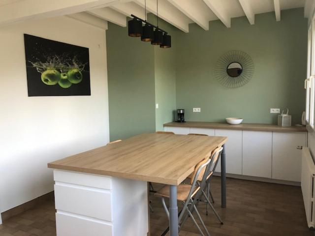 a kitchen with a wooden table in a room at Le 21 in Écuires