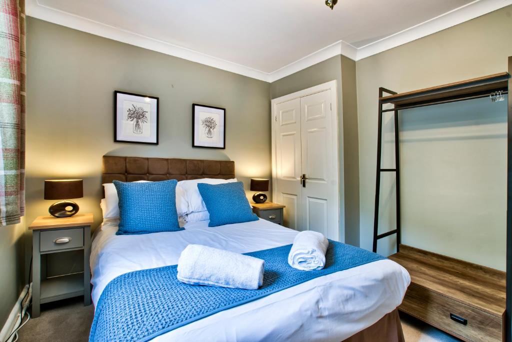 a bedroom with a large bed with blue pillows at The Vines Hotel in Alvescot