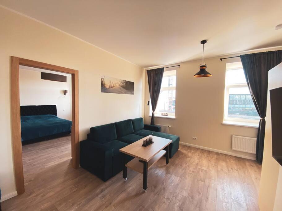 a living room with a couch and a table at Cozy Apartment Kaija in Liepāja
