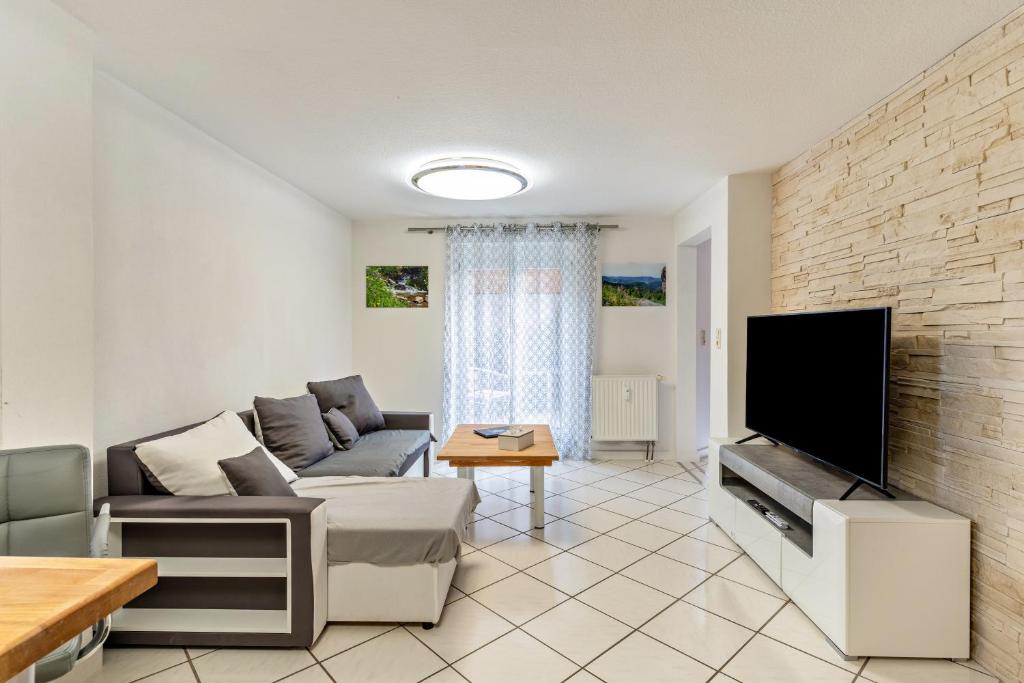 ein Wohnzimmer mit einem Sofa und einem Flachbild-TV in der Unterkunft Ribeiro Tesouro in Friesenheim