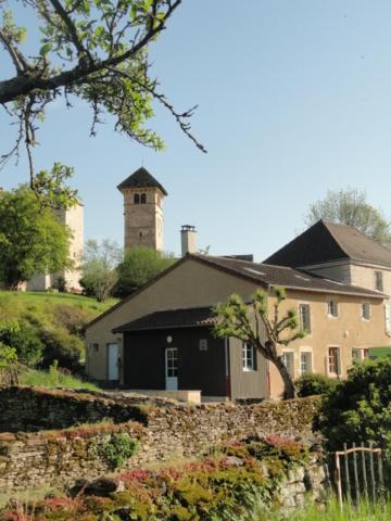 a large house with a clock tower on a hill at Les chambres de Blanot in Blanot