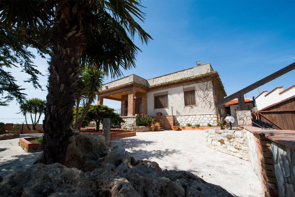 une maison avec un palmier en face dans l'établissement Villa del Tramonto, à Partanna