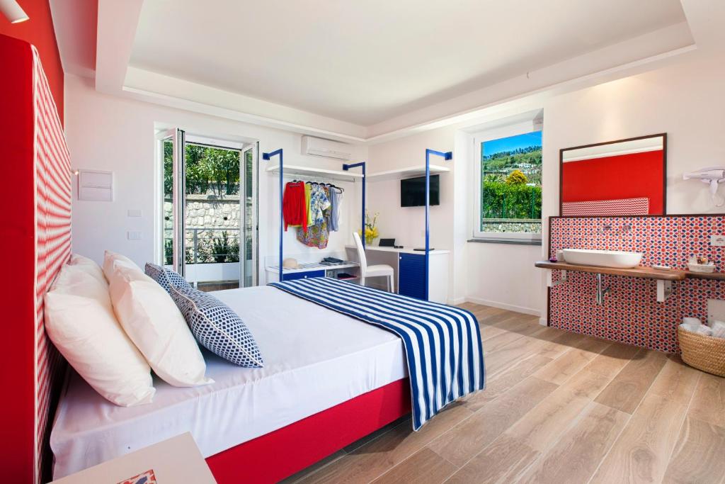 um quarto com uma cama vermelha e branca e uma casa de banho em YourHome - Relais Loggia Li Galli em Massa Lubrense