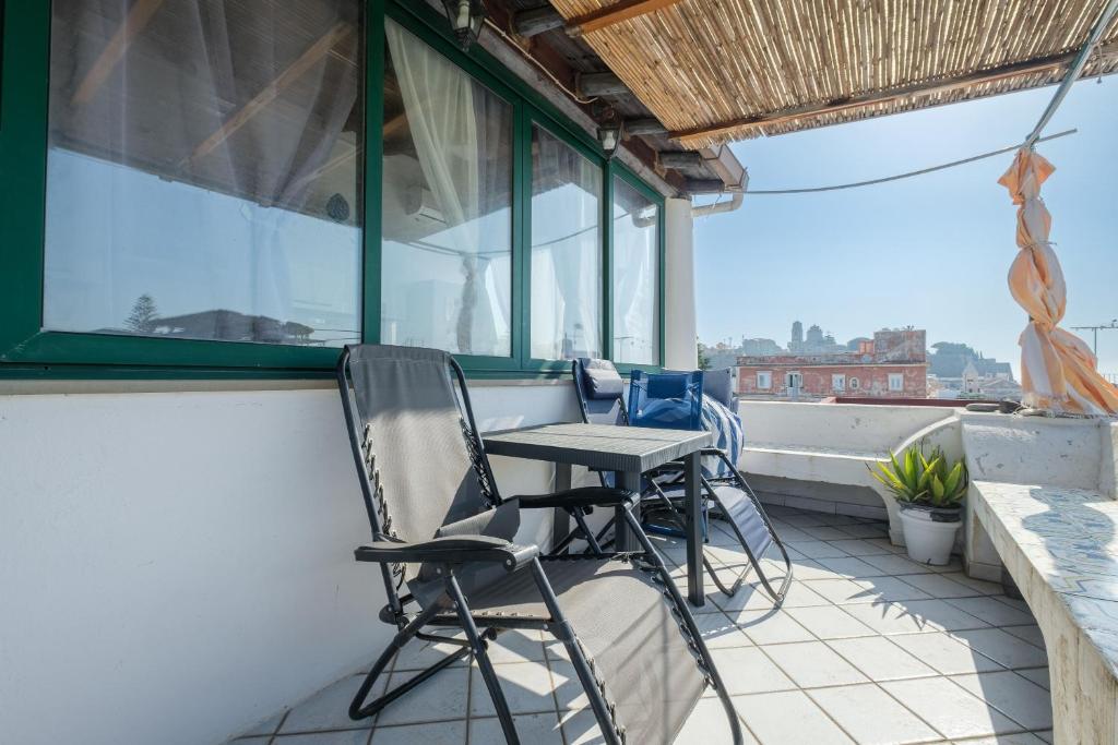 eine Terrasse mit Stühlen und einem Tisch auf dem Balkon in der Unterkunft Angela Appartament in Lipari