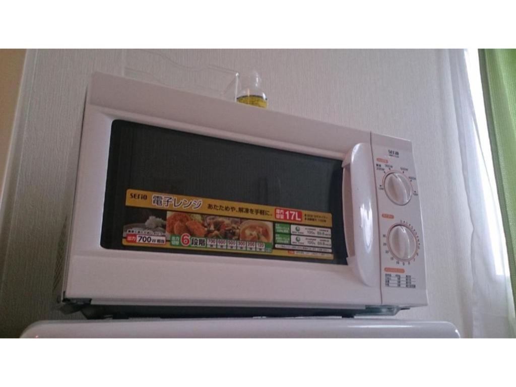 a microwave oven sitting on top of a refrigerator at Sora / Vacation STAY 1124 in Sakai