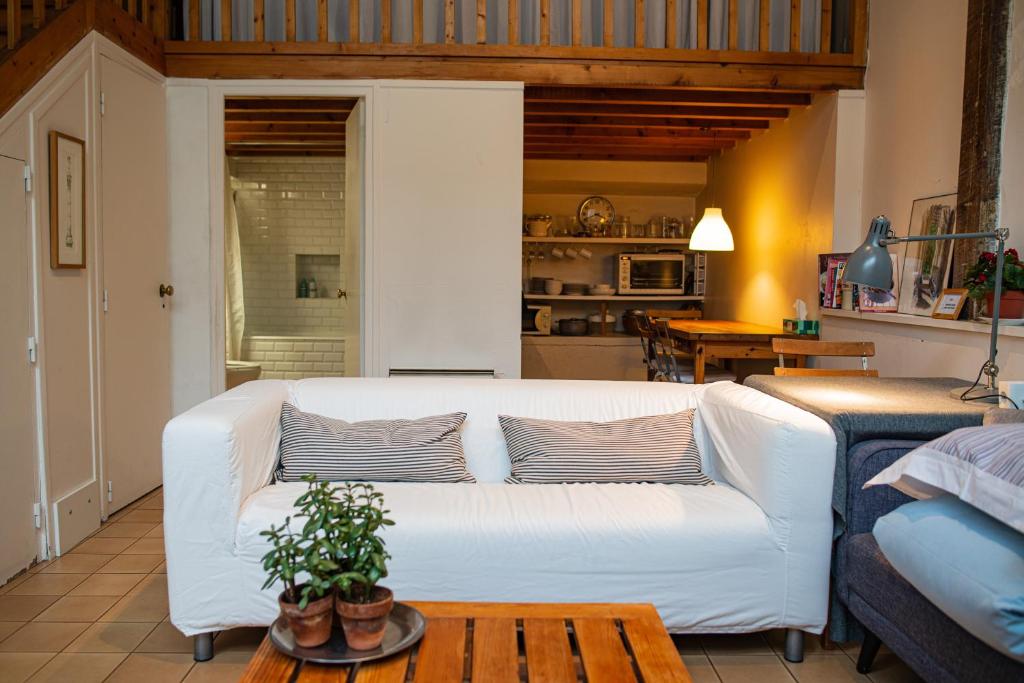 uma sala de estar com um sofá branco e uma mesa em Le Garage em Paris