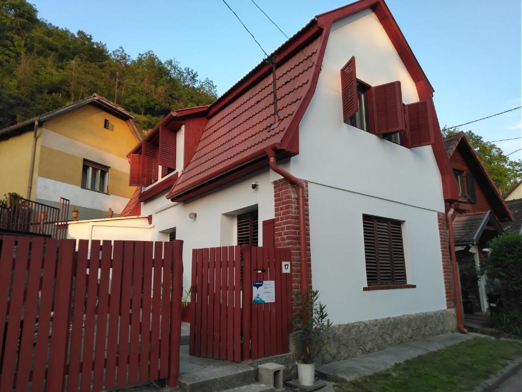 a white and red house with a red fence at Szőnyi úti vendégház in Zebegény