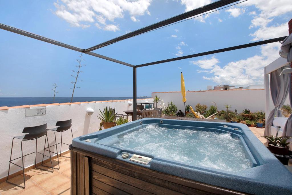 uma banheira de hidromassagem no telhado de uma casa em Casa Karma em Arico