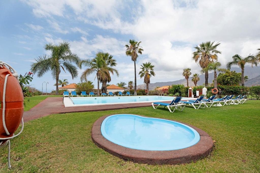 duży basen z leżakami i palmami w obiekcie La Villa La Palma- 2 dormitorios A w mieście Los Barros