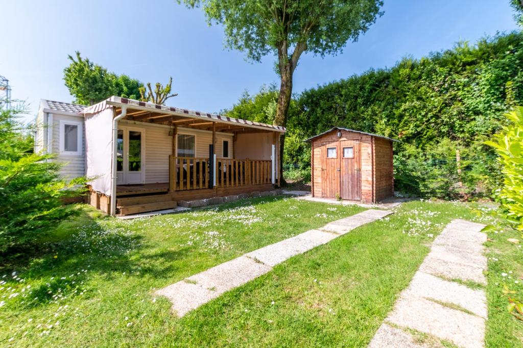 a house with a garden and a small shed at Mobil home Le Denver in Noyelles-sur-Mer