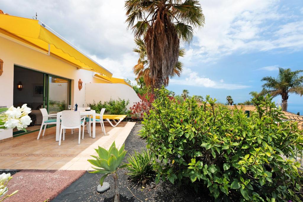 a patio with a table and chairs on a house at Villa Verde Superior A in Los Barros