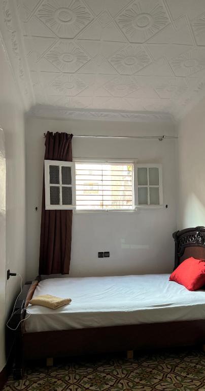 a large bed in a room with a window at Riad Del Rey in Rabat