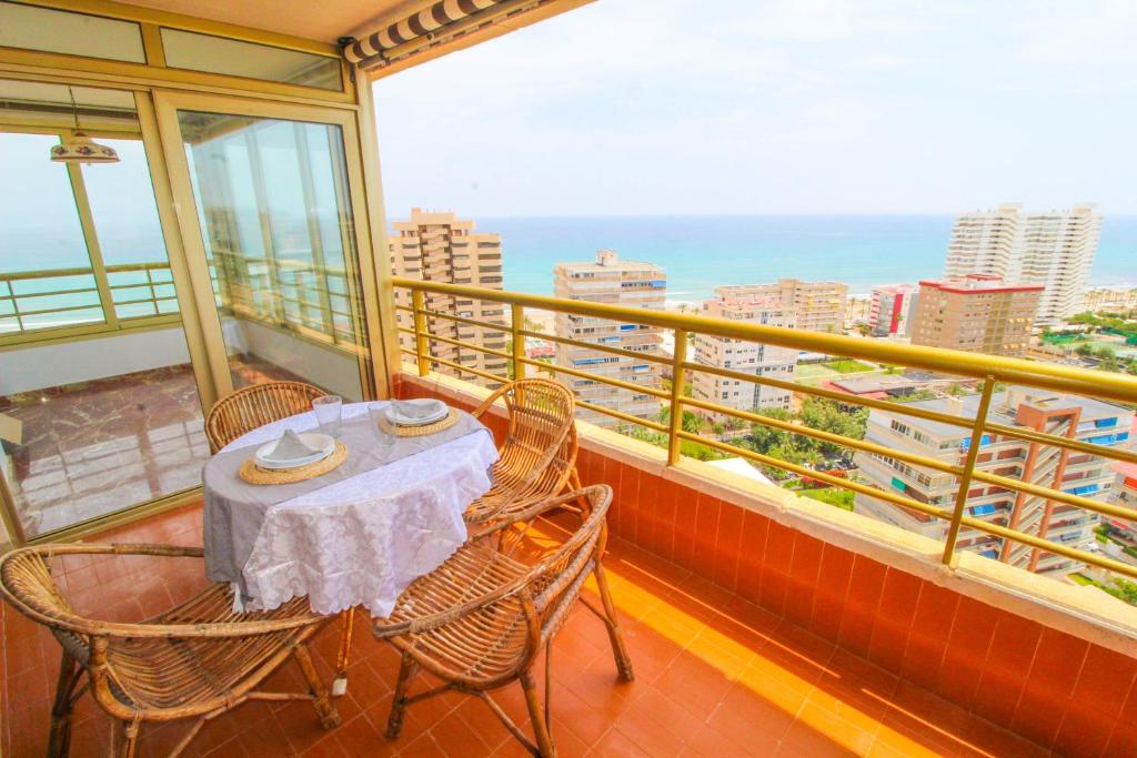 una mesa y sillas en un balcón con vistas en 1 min a pie Playa San Juan. Increíbles vistas al mar. Urbanización con piscina, padel y tenis., en Alicante