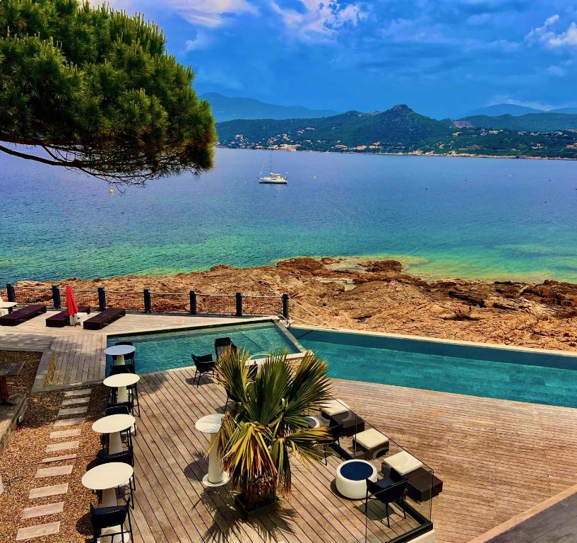 uma piscina com vista para a água em Hôtel Castel d'Orcino em Calcatoggio