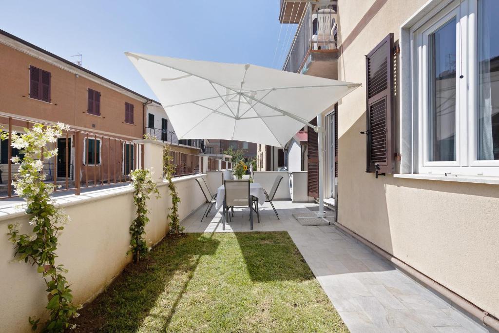 un parapluie blanc assis sur le côté d'un bâtiment dans l'établissement Appartamento 4, à Ameglia