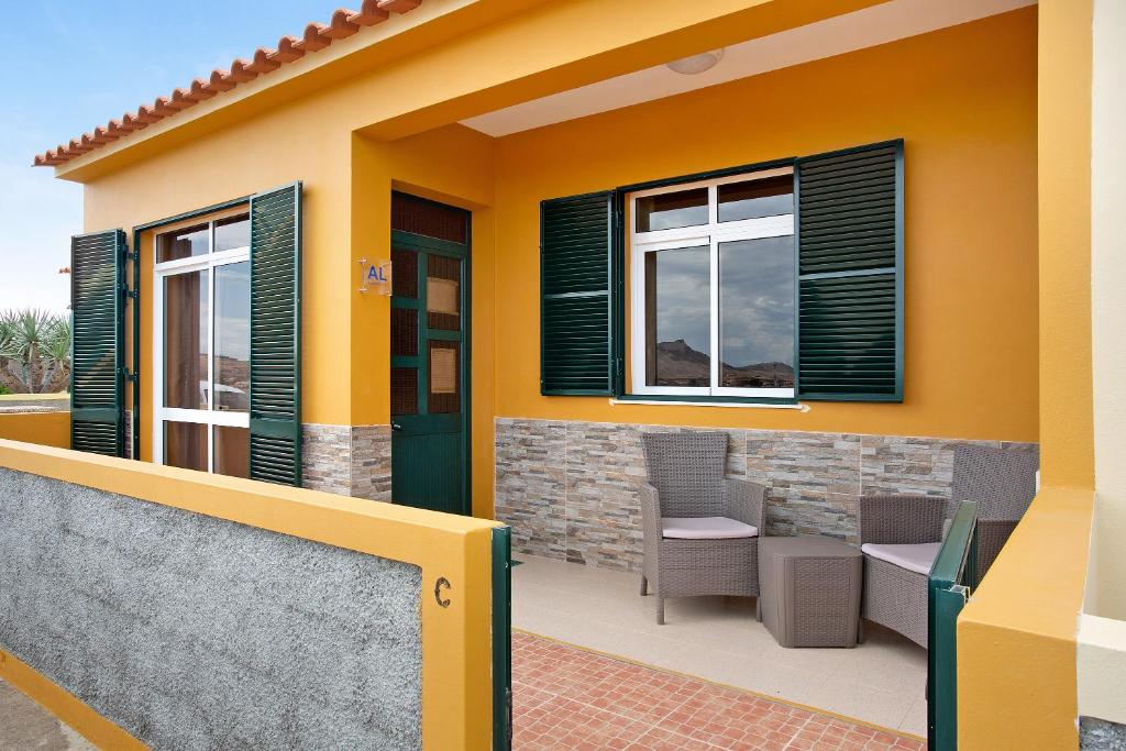 una casa con paredes y ventanas verdes y amarillas en Cantinho Solpraia, en Porto Santo