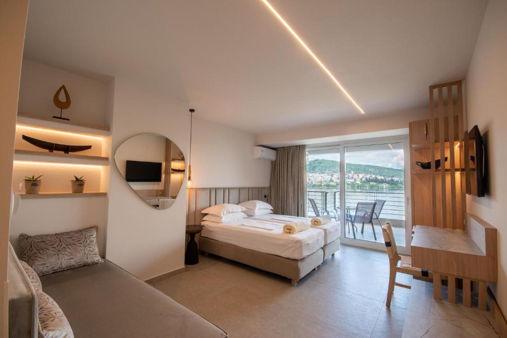 a hotel room with a bed and a balcony at Paralimnio Suites in Kastoria