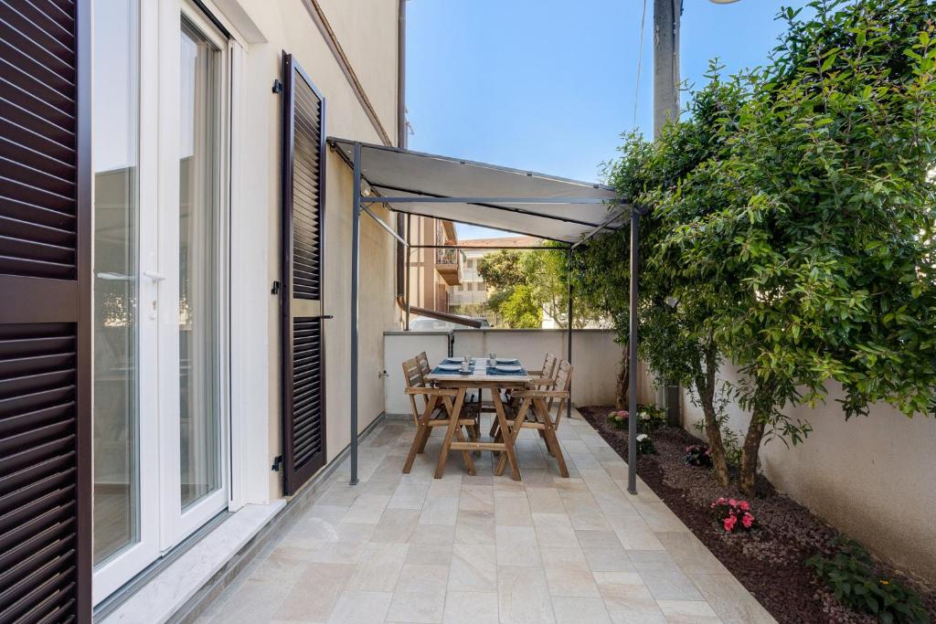 Fiumaretta di AmegliaAppartamento 2的露台配有桌椅和遮阳伞