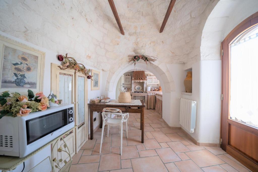 a kitchen with a table and chairs in a room at Trullo Leone in Martina Franca