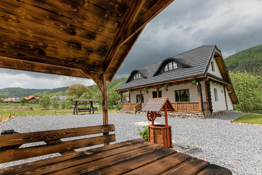 une maison avec un banc devant un bâtiment dans l'établissement Old Cottage, à Bran