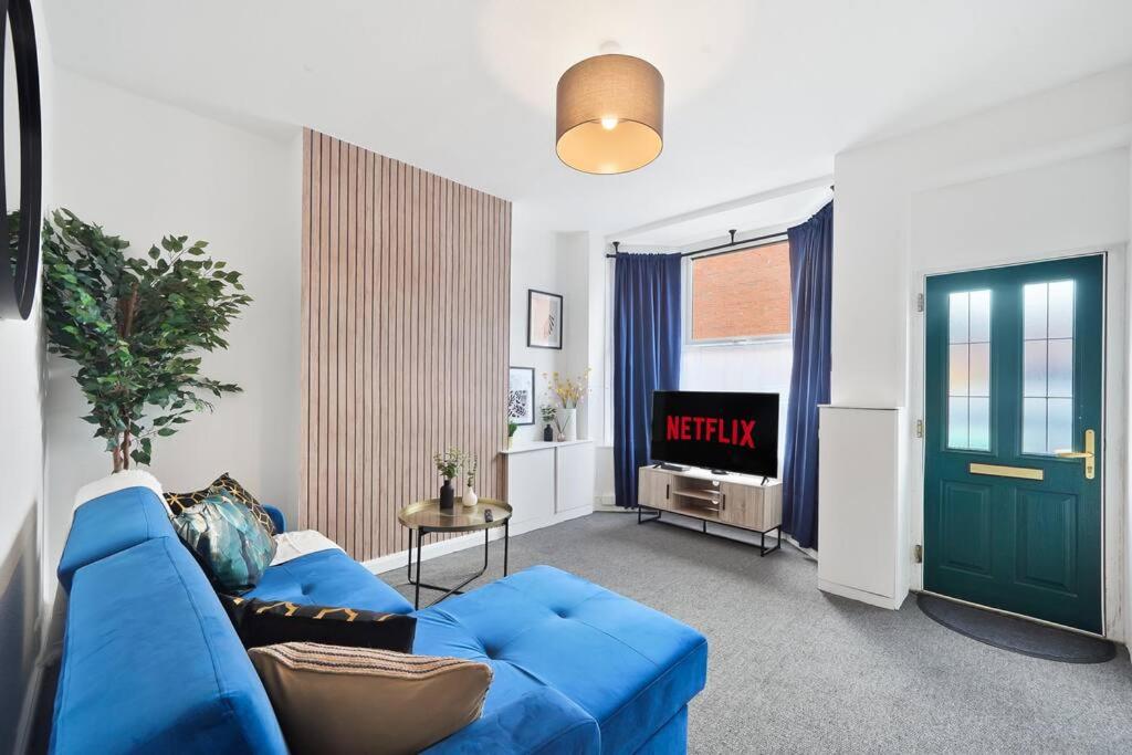 a living room with a blue couch and a tv at Elegant Scandi Gem of Nottingham - Sleeps 10 in Nottingham