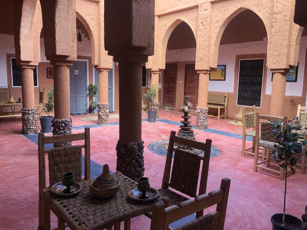 a room with a table and chairs in a building at Riad Nkob in Nkob