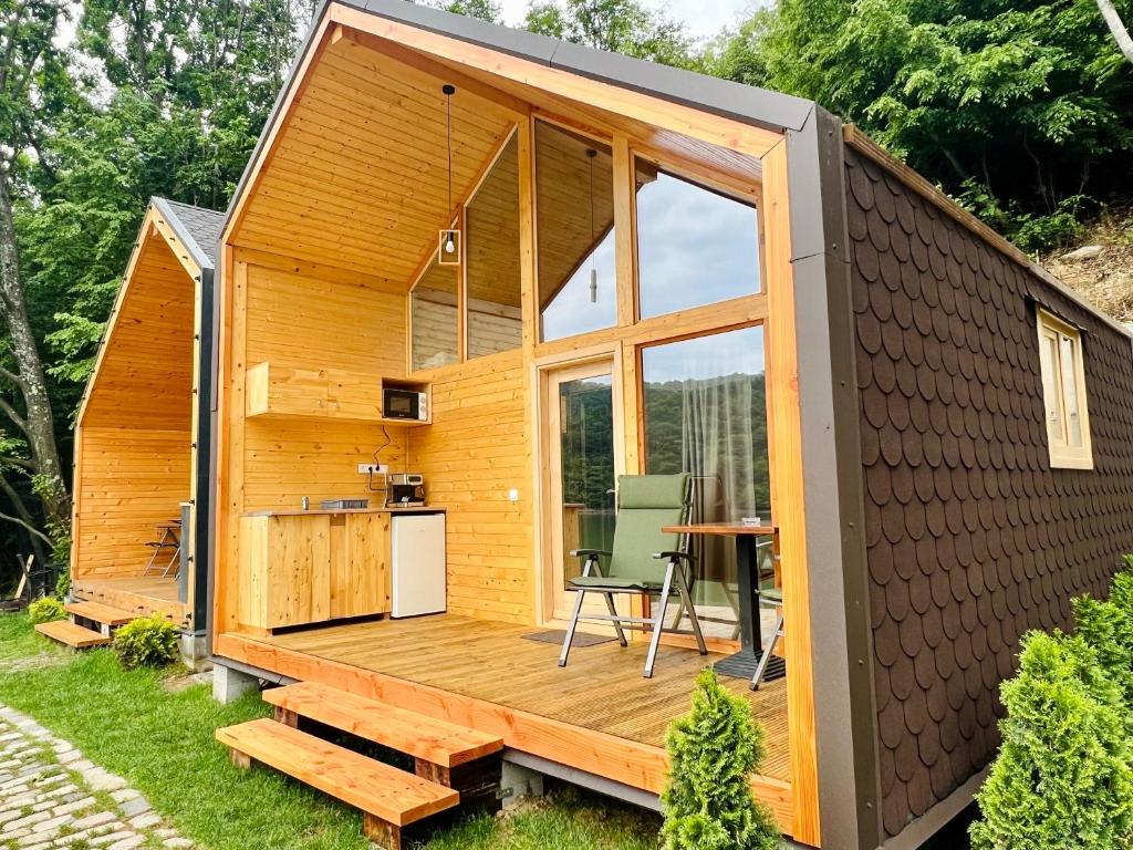 a tiny house with a deck and a table at Cabana Bahna 2 in Orşova
