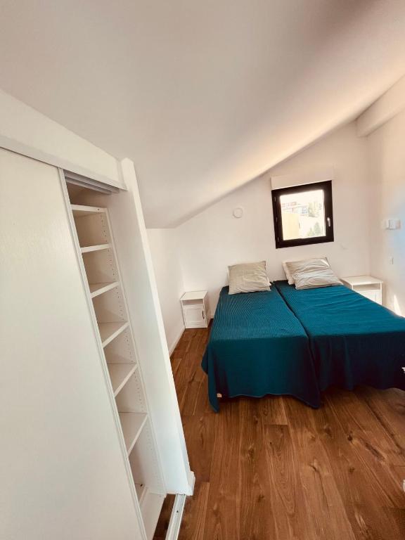 Schlafzimmer mit einem Bett mit blauer Tagesdecke in der Unterkunft Magnifique Duplex Contemporain Climatisé Jacuzzi Ref Duplex Vill&#39;Attilio in Drammont