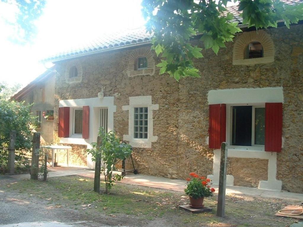 蒙德馬桑的住宿－Garrelon，一座石屋,设有红色百叶窗和庭院