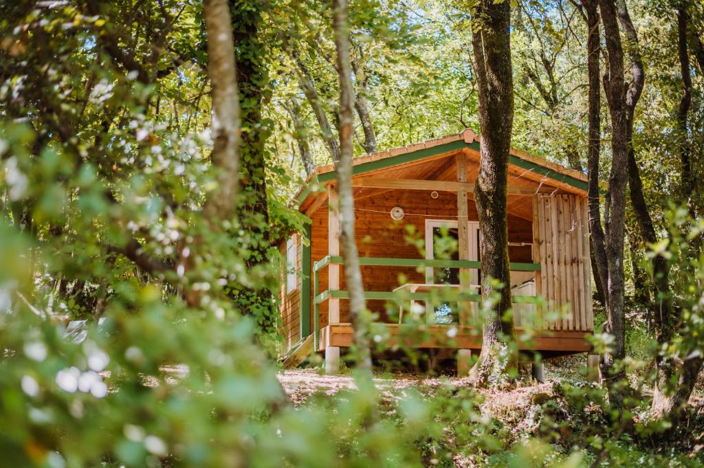 a wooden cabin in the woods with trees at Camping Sunêlia la Clémentine in Cendras