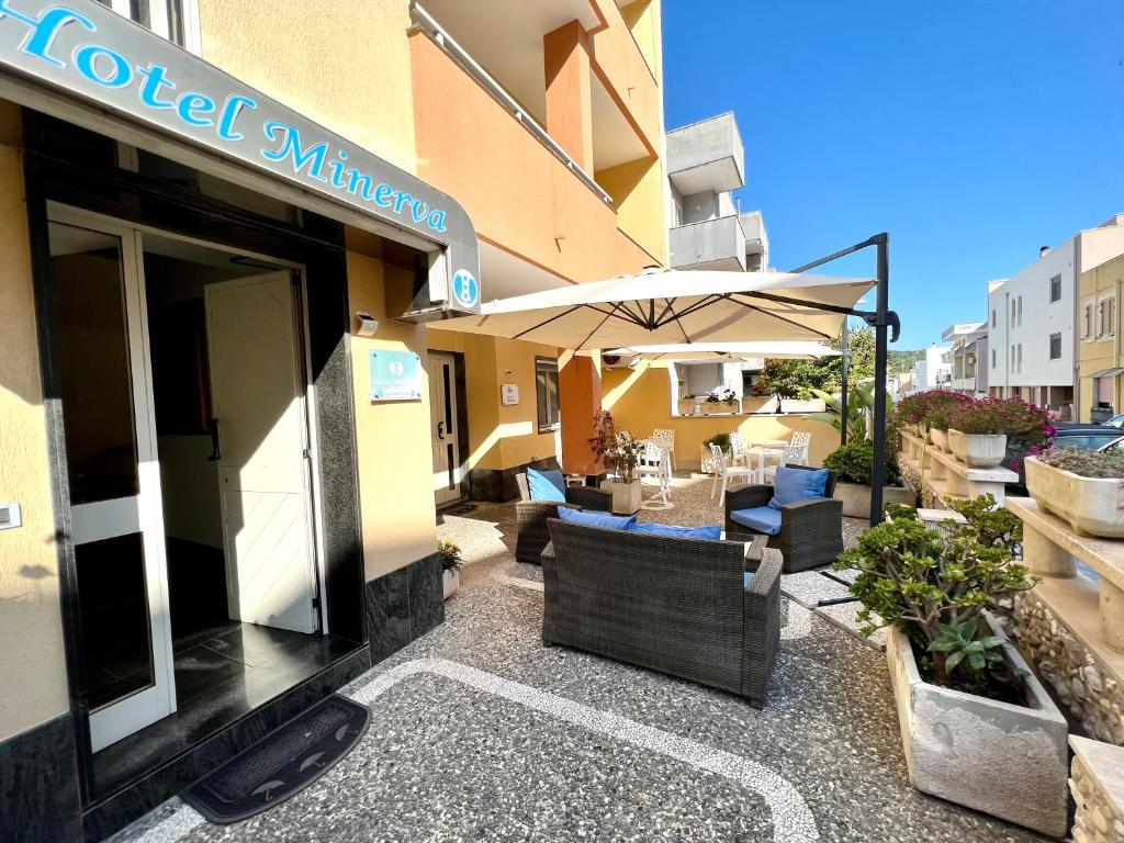an outdoor patio with chairs and an umbrella at Hotel Minerva in Otranto