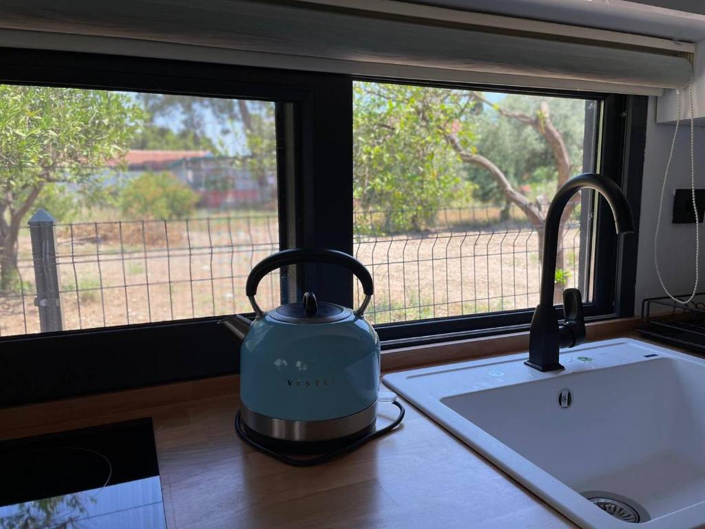 Sea Life Homes في كيمير: غلاية الشاي على منضدة المطبخ بجانب النافذة