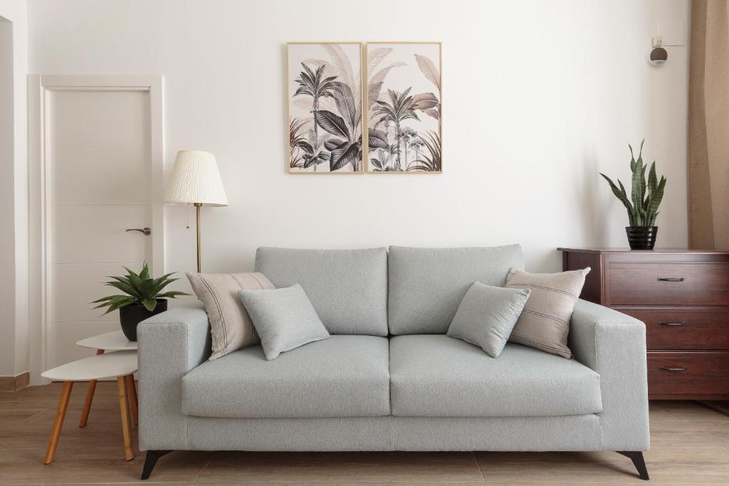 un sofá gris en una sala de estar con una foto en la pared en Sagrada Familia Apartment, en Barcelona