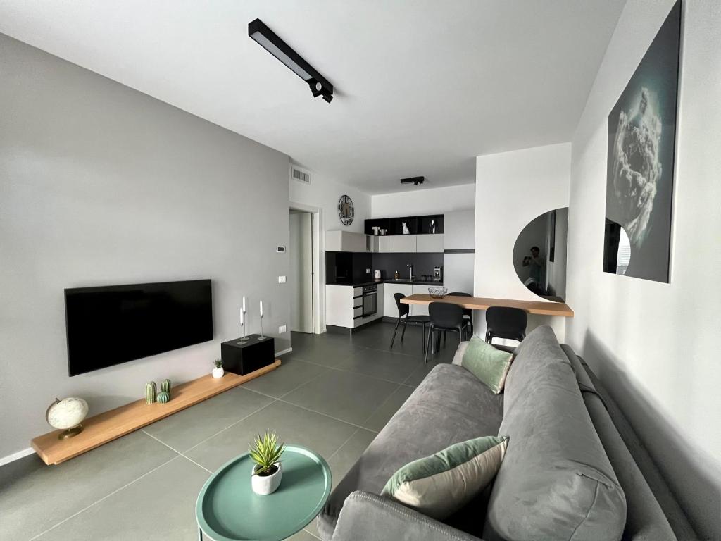 a living room with a couch and a tv at SeaCity Vibes Apartments in Monopoli