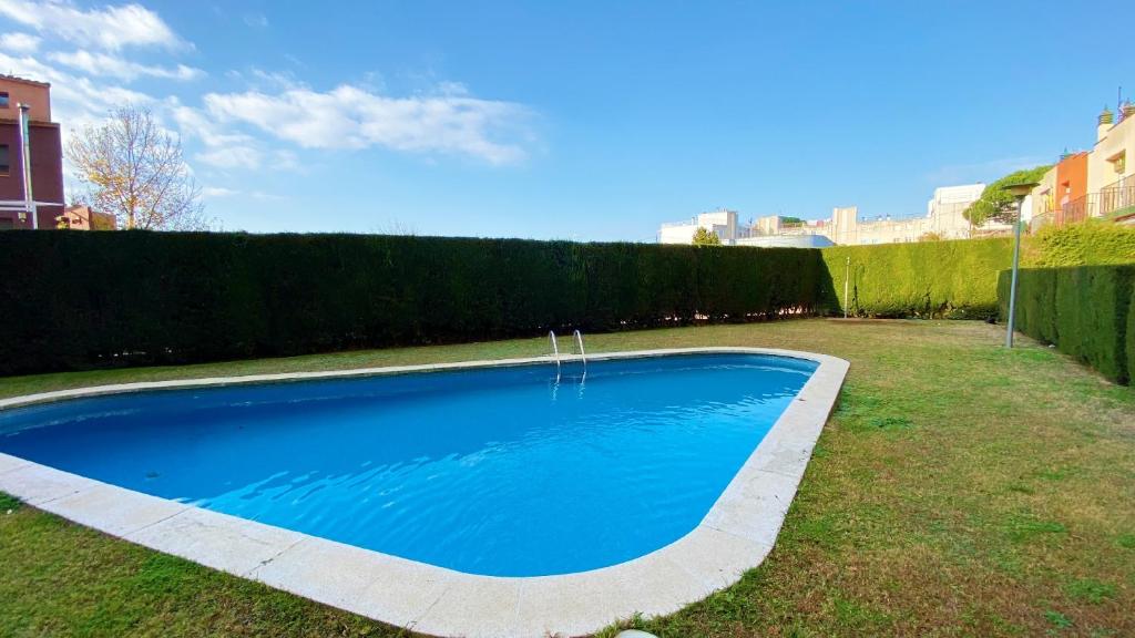 una gran piscina azul en un patio en Sonora Golf and rest apartment, en Santa Cristina d'Aro