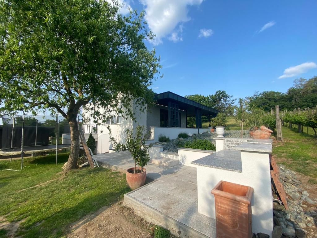 una casa con un árbol en el patio en Terra Toscana Apartman, en Sárvár