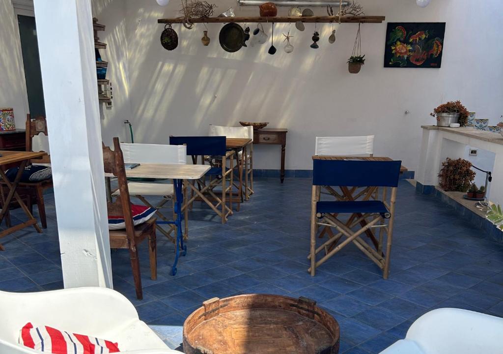 una sala da pranzo con tavoli e sedie in legno di A' BITTA a Favignana