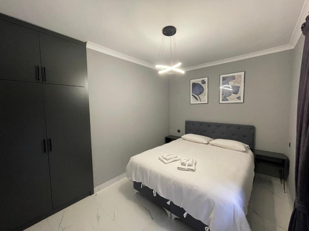 1 dormitorio con 1 cama con 2 zapatillas en Continental Trabzon Suite&Apartments, en Trabzon