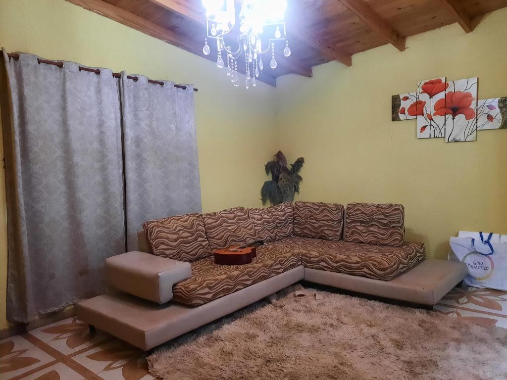 sala de estar con sofá y lámpara de araña en Hospedaje Mizael en Puerto Iguazú