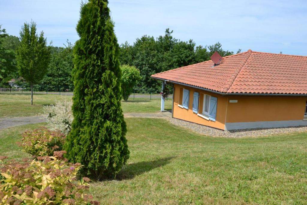 a small house with a tree in the yard at Gabardan in Mugron