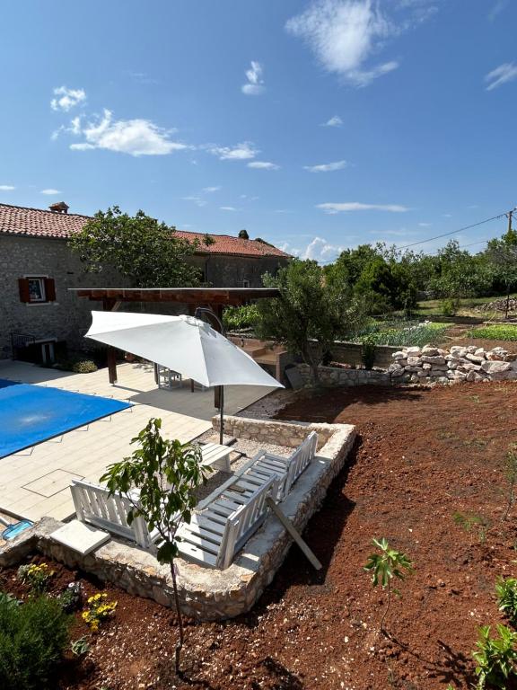 um grupo de cadeiras e um guarda-sol junto a uma piscina em Bonvivan House em Diminići