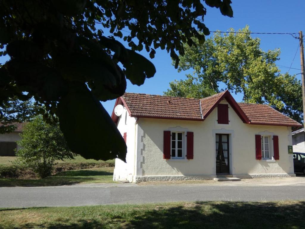 uma pequena casa branca com um telhado vermelho em Le moulin em Préchacq