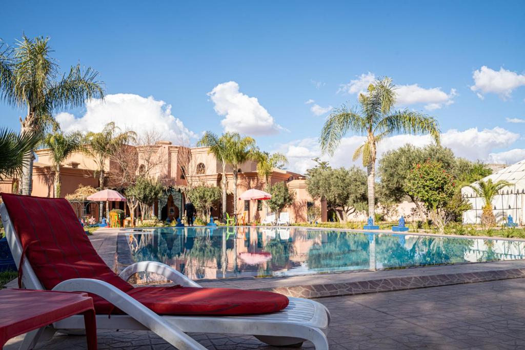 una sedia accanto alla piscina in un resort di Las Palmeras Guest House a Marrakech