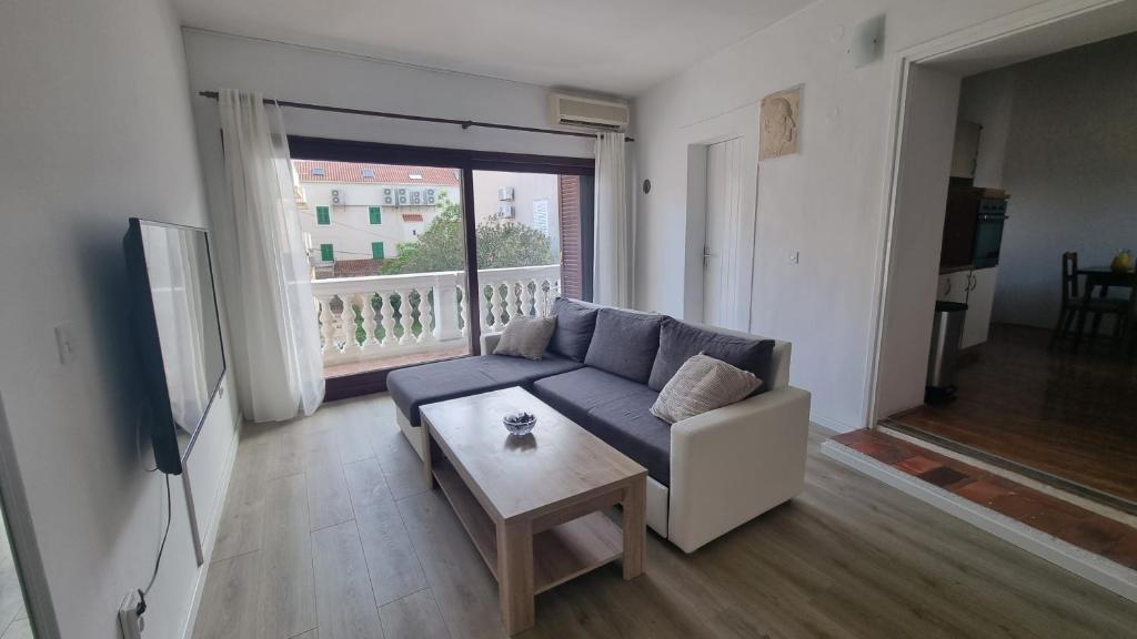 ein Wohnzimmer mit einem Sofa und einem Tisch in der Unterkunft Ivory Apartment in Biograd na Moru