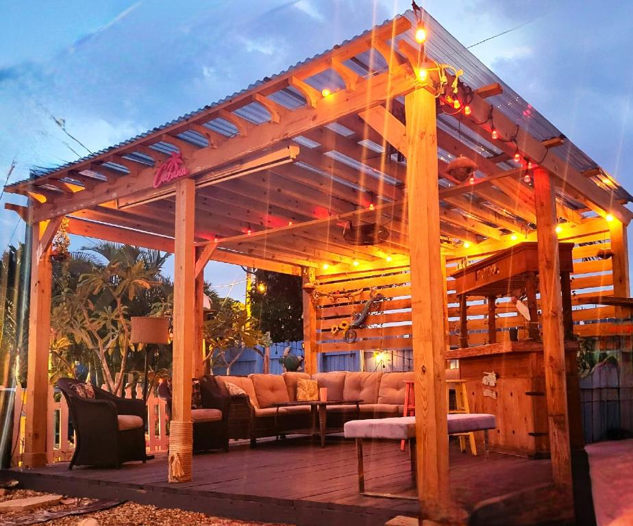 a wooden pergola with couches and lights on it at Hidden Oasis in West Palm Beach