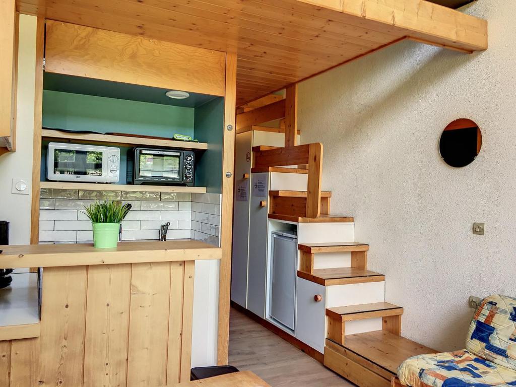 una cocina con fregadero y una escalera en una casa pequeña en Studio Les Arcs 1800, 1 pièce, 4 personnes - FR-1-346-510, en Arc 1800
