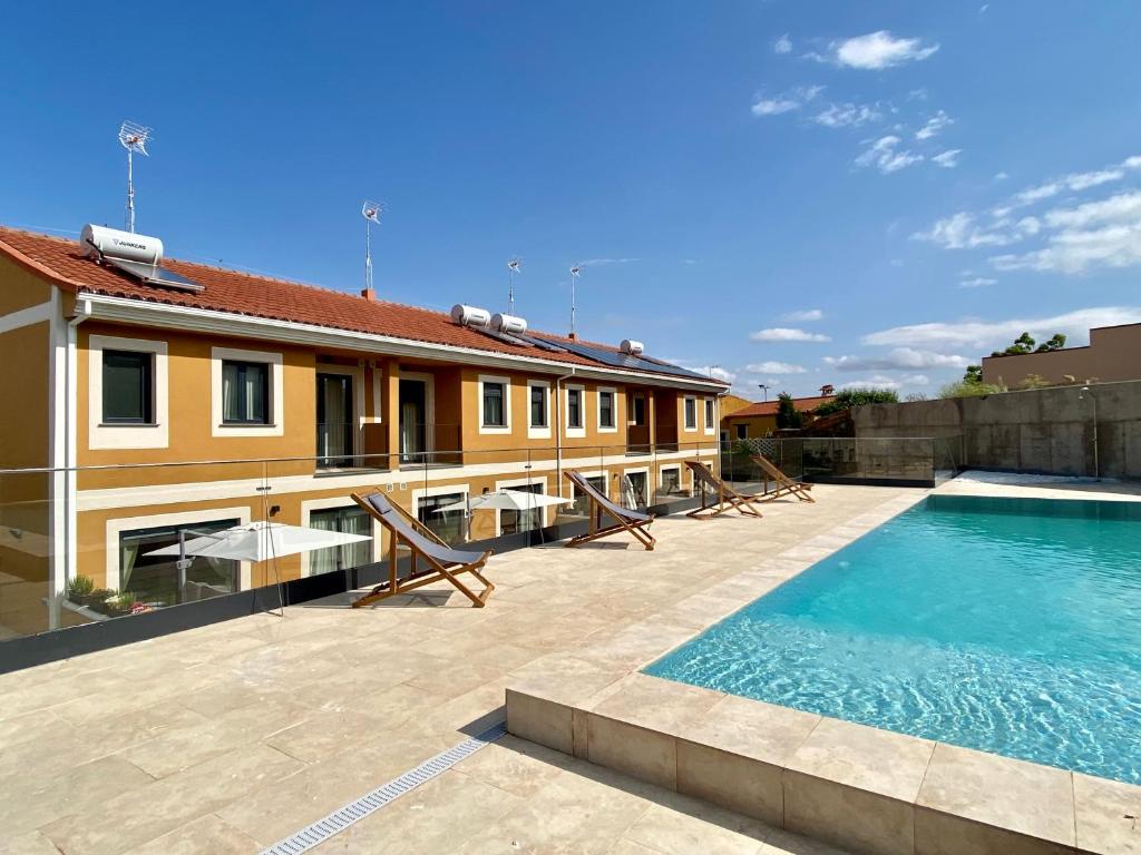 a house with a swimming pool next to a building at Casas La Fuente de Saelices - Alojamiento rural in Saelices el Chico