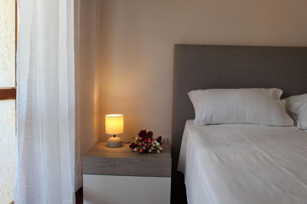 una camera da letto con un letto con una lampada e fiori di Appartamenti Orchidea a Tropea