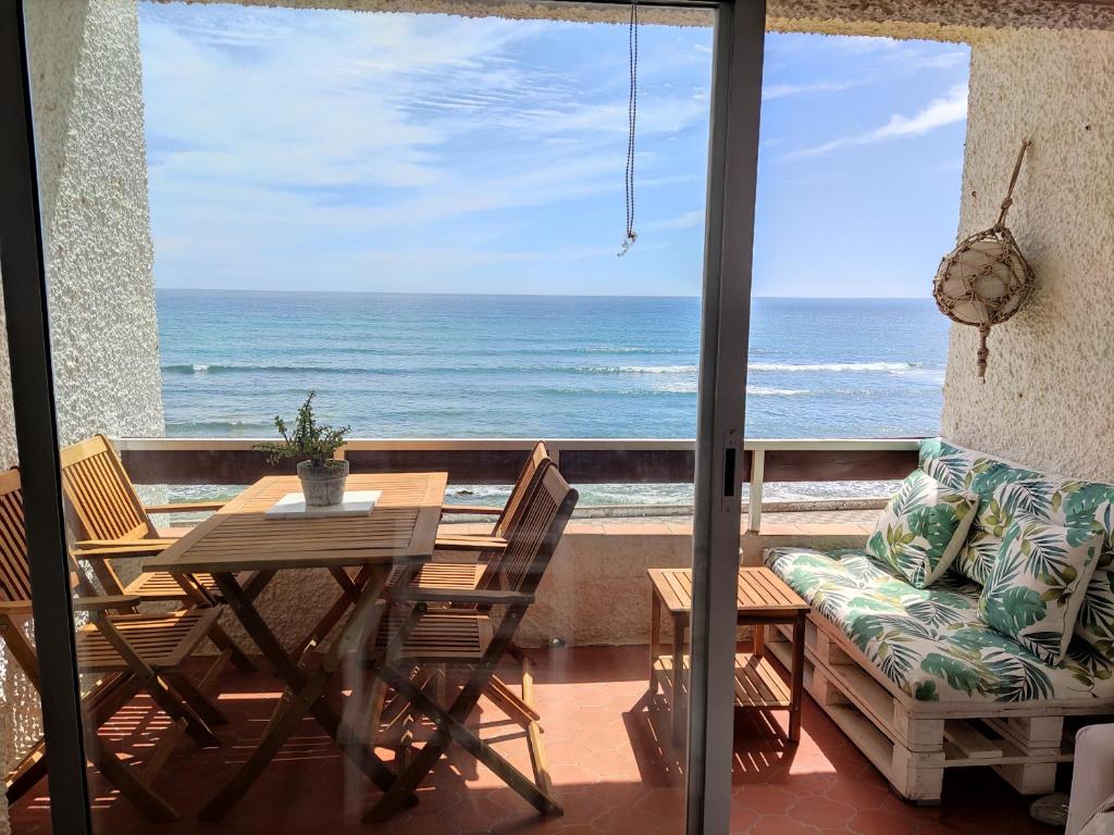 balcone con tavolo, sedie e vista sull'oceano di Caños de Meca Apartamento frente al mar a Los Caños de Meca